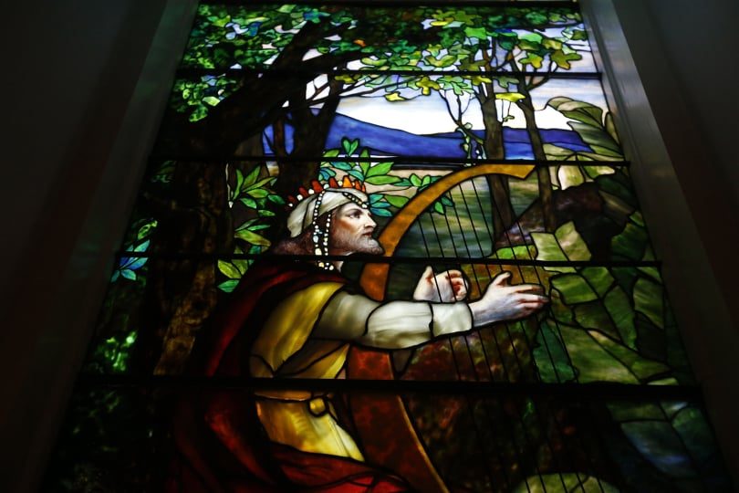 Tiffany stained glass window of a figure playing a harp